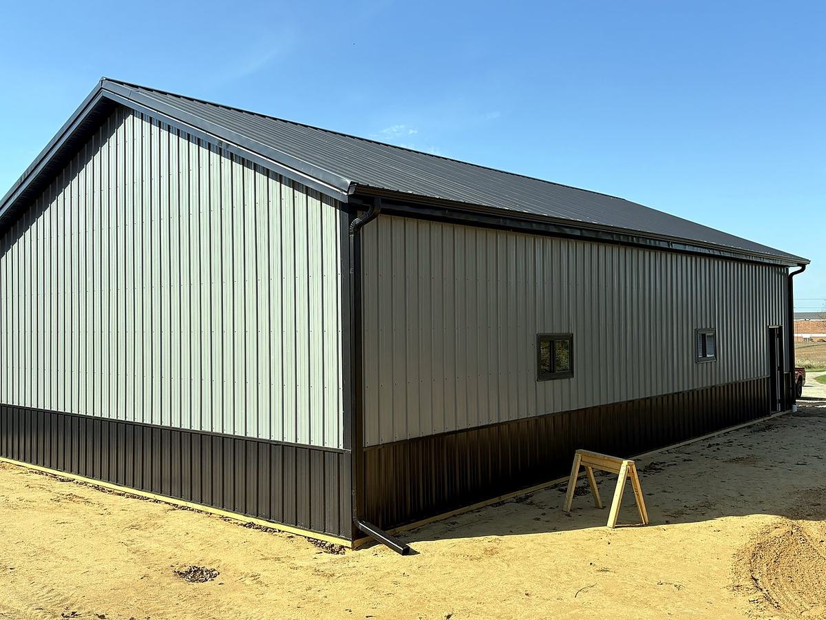 Gray and black post frame building with steel roof built by Great Lakes Post Frame
