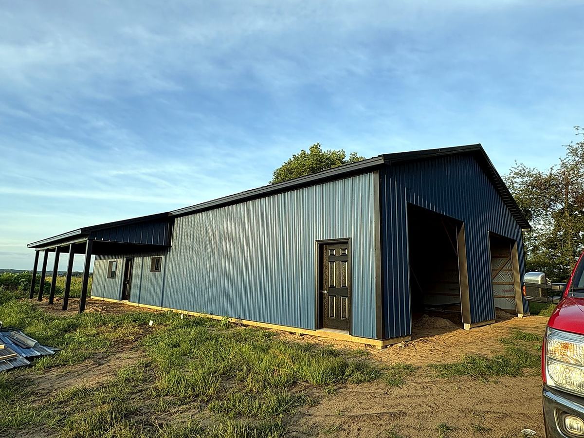 Blue-gray pole barn with open lean-to porch along the side